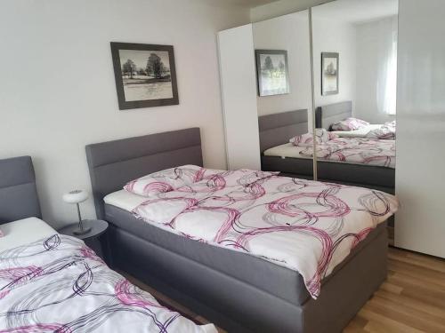 1 Schlafzimmer mit 2 Betten und einem Spiegel in der Unterkunft Ferienwohnung an der Saline in Bad Rothenfelde