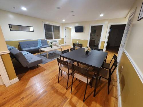 sala de estar con mesa y sofá en Classy 3 bed near NYC with view! en Union City