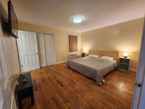 a bedroom with a bed and wooden floors and two lamps at Classy 3 bed near NYC with view! in Union City