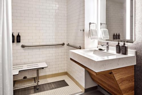 a white bathroom with a sink and a mirror at Sheraton Phoenix Downtown in Phoenix