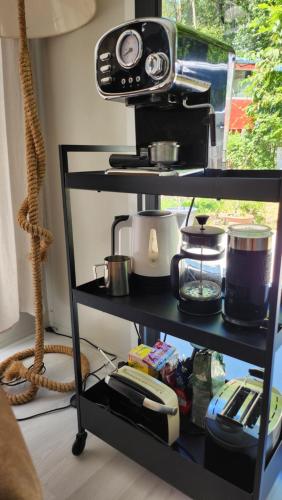 a black shelf with a toaster and other kitchen items at OFFGRID Haus am Angelteich in Thallern