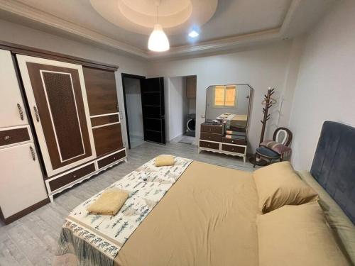 a bedroom with a large bed and a mirror at Large3BDR Apartment lovely place Front of auc and Point 90 mall in Cairo