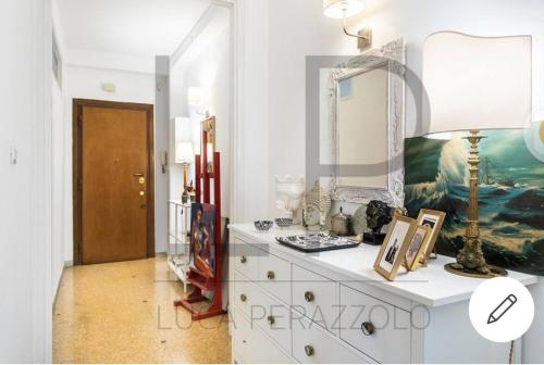 eine weiße Kommode mit einem Spiegel und einer Lampe drauf in der Unterkunft San Pietro Vaticano Family House in Rom