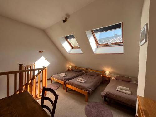 a attic room with two beds and a table at Appartement Oz Village in Oz