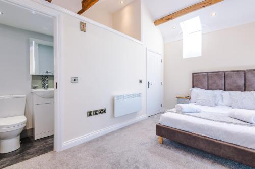 a bedroom with a bed and a toilet and a sink at Unique 2-bed barn in Beeston by 53 Degrees Property, ideal for Families & Friends, Great Location - Sleeps 4 in Beeston