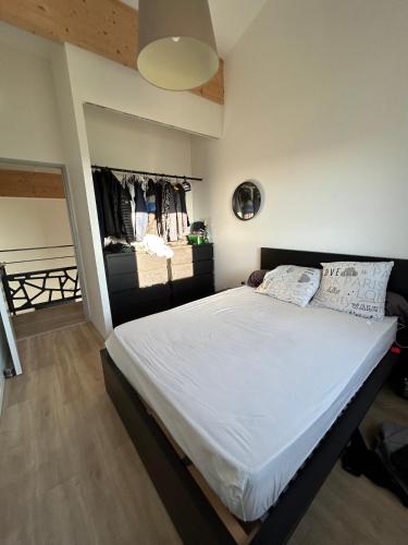 - une chambre avec un grand lit et des draps blancs dans l'établissement Villa avec piscine, à Saint-Jean-Bonnefonds