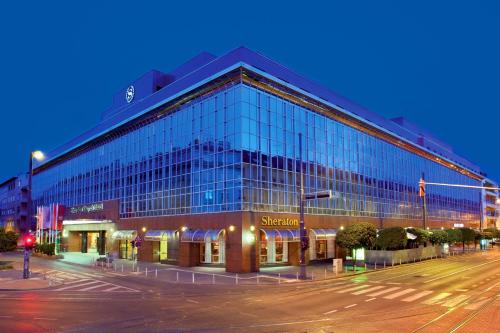 a large glass building on a city street at night at Sheraton Zagreb Hotel in Zagreb