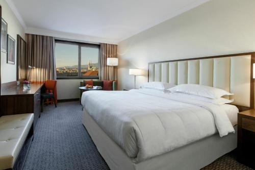 a large hotel room with a large bed and a desk at Sheraton Zagreb Hotel in Zagreb