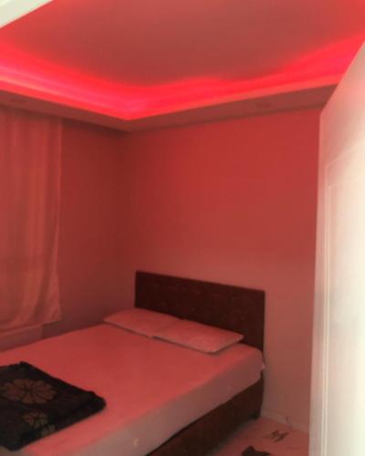 um quarto com uma cama com luzes vermelhas no tecto em Antikoglu em Mardin