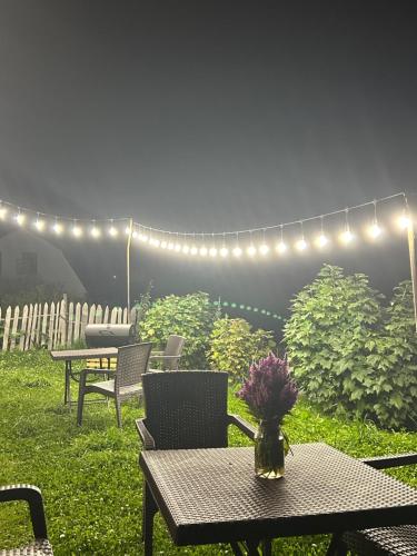 a patio with a table and chairs and lights at MTASHI - მთაში in Ushguli