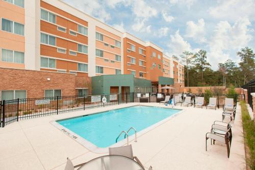 une image d'une piscine en face d'un bâtiment dans l'établissement Courtyard by Marriott Houston City Place, à Spring