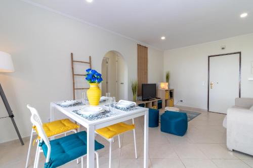 un soggiorno con tavolo bianco e vaso sopra di Apartment Breeze located in the heart of Carvoeiro a Carvoeiro