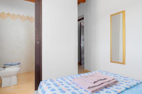 uma casa de banho com uma cama, um WC e um espelho. em Tenuta Villa Marianna - Almiddina em Telti