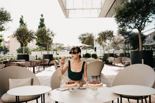 a woman sitting at a table with cake at Address Istanbul in Istanbul