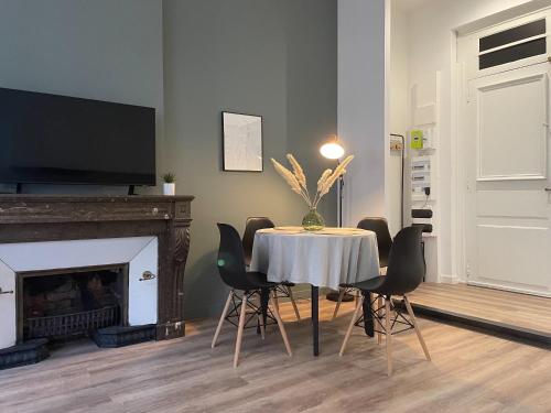 une salle à manger avec une table, des chaises et une télévision dans l'établissement L'iris, à Saint-Étienne