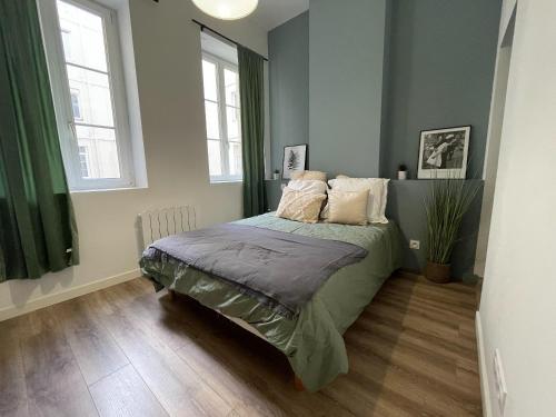 une chambre avec un lit et deux fenêtres dans l'établissement L'iris, à Saint-Étienne