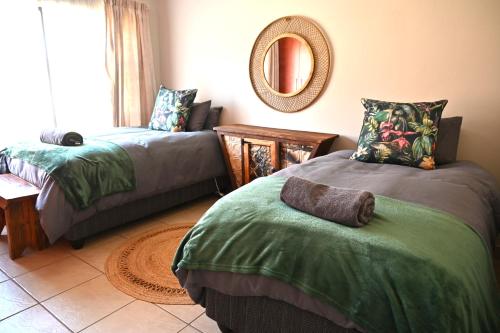 a living room with two beds and a mirror at Summersun Village in Parys