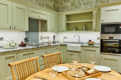 a kitchen with a wooden table with wine glasses on it at The Filly in Hexham