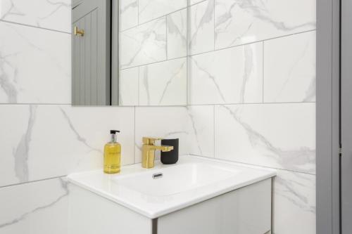 a white bathroom with a sink and a mirror at Wainscott Terrace - Spacious 2 double bedroom house with on-street parking short walk away from seafront in Portsmouth
