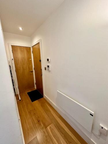 a hallway with a door and a wooden floor at Comfort Stay Apartment in Haywards Heath