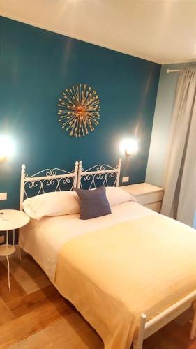 a bedroom with a white bed with a blue wall at Villino rosso in Taormina
