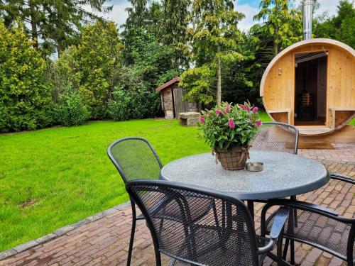 a patio table with chairs and a potted plant on it at Secret Wellness Lonneker in Enschede