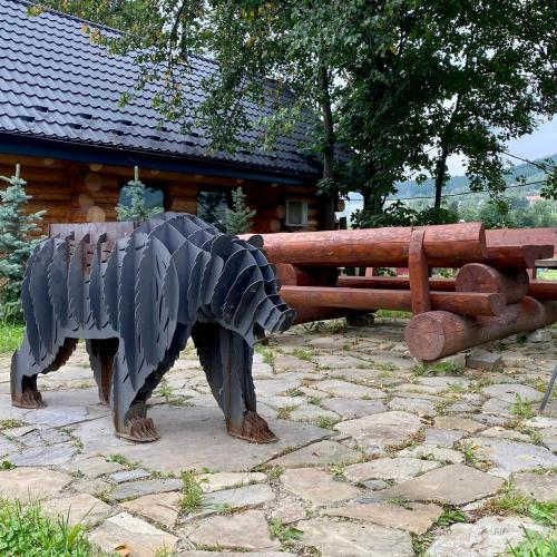 a statue of a bear standing next to a wooden fence at Chalet PidStromom in Mykulychyn