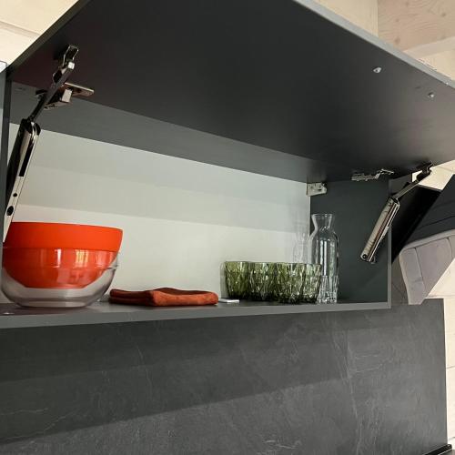 a shelf in a kitchen with a bowl and glasses at Chalet PidStromom in Mykulychyn