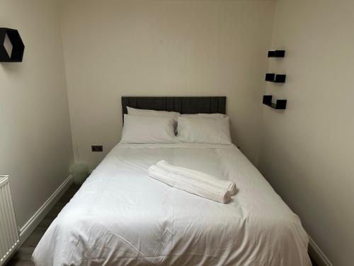 a white bed with a white blanket on it at Stunning Double room one in Bedford
