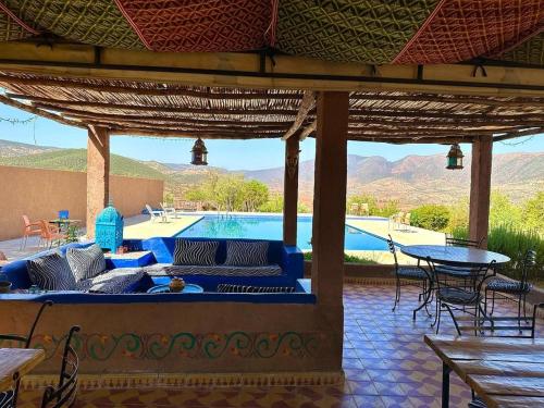 a patio with a bed and a swimming pool at Camping Auberge Zebra in Ouzoud