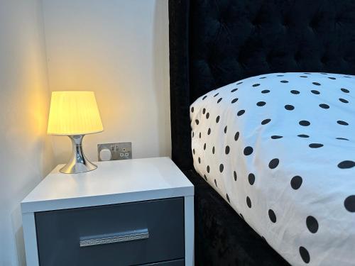 a bed with a black headboard and a lamp on a nightstand at Comfort Stay Apartment in Haywards Heath