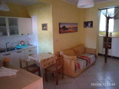 ein Wohnzimmer mit einem Sofa und einem Tisch in der Küche in der Unterkunft Lightbluevillageresortbeachsl in Catania