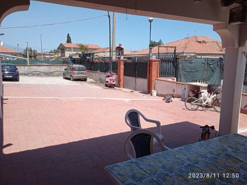 eine Terrasse mit einem Tisch und Stühlen auf einem Tennisplatz in der Unterkunft Lightbluevillageresortbeachsl in Catania