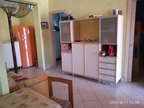 ein Wohnzimmer mit einem großen Schrank und einem Kühlschrank in der Unterkunft Lightbluevillageresortbeachsl in Catania