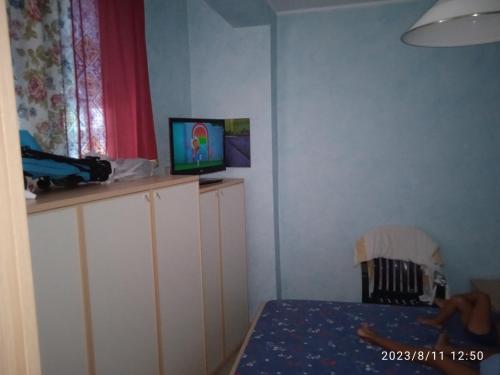 Schlafzimmer mit einem Bett und einem TV auf den Schränken in der Unterkunft Lightbluevillageresortbeachsl in Catania