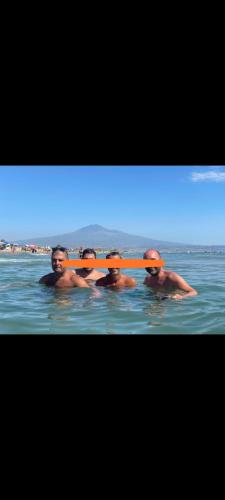 Eine Gruppe Männer im Wasser mit einem Paddel in der Unterkunft Lightbluevillageresortbeachsl in Catania
