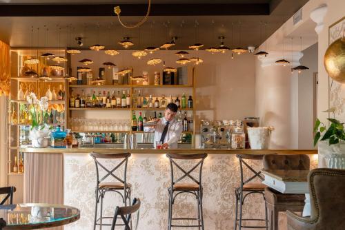 a man standing behind a bar in a restaurant at Hotel Mazzanti in Milano Marittima