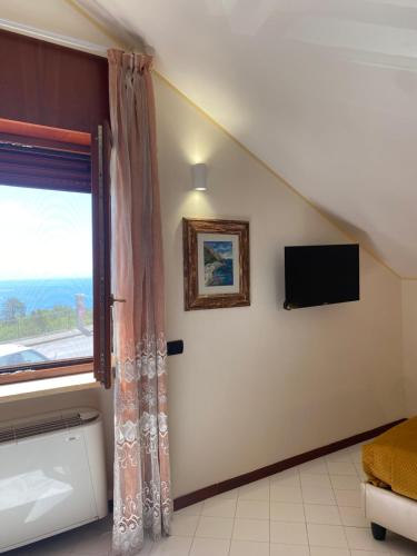Pokój z oknem i telewizorem na ścianie w obiekcie Bed & Breakfast Casa Anna Rita w mieście Vietri sul Mare