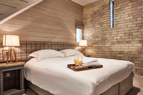 a bedroom with a large bed with a wooden wall at The Hayloft in Hexham