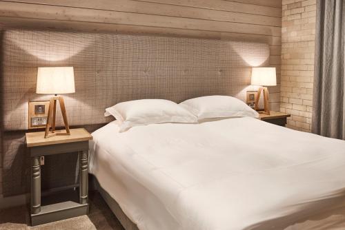 ヘクサムにあるThe Hayloftの大きな白いベッドと2つのランプのある寝室