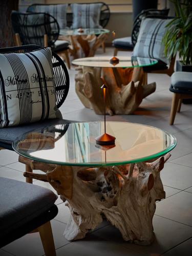 a table made out of a tree stump with a glass top at Hotel Mazzanti in Milano Marittima