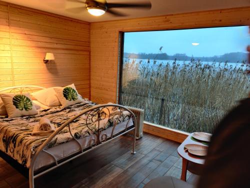 um quarto com uma cama e uma grande janela em Hotel Zamek Karnity em Milomlyn