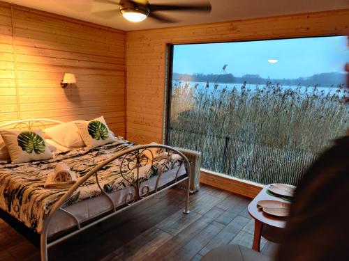 a bedroom with a bed and a large window at Hotel Zamek Karnity in Miłomłyn