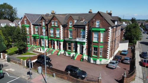 an apartment building with cars parked in a parking lot at Castle Lodge Guest House 86-88 Sheil Rd L6 3AF in Liverpool