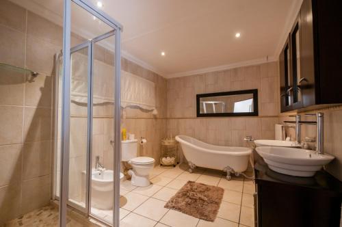 uma casa de banho com uma banheira, um WC e um lavatório. em Zuikerkop Country Game Lodge em Clocolan