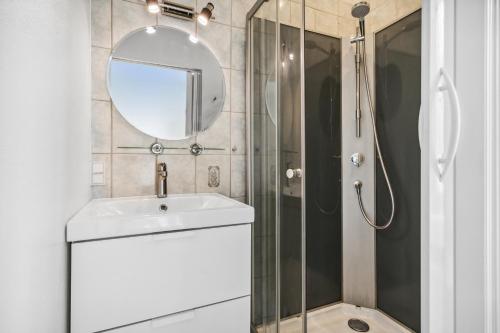 uma casa de banho com um chuveiro, um lavatório e um espelho. em Lejlighed i hjertet af Aalborg em Aalborg