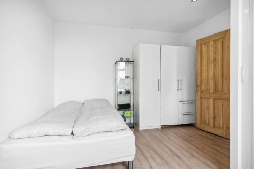 a white bedroom with a bed and a closet at Lejlighed i hjertet af Aalborg in Aalborg