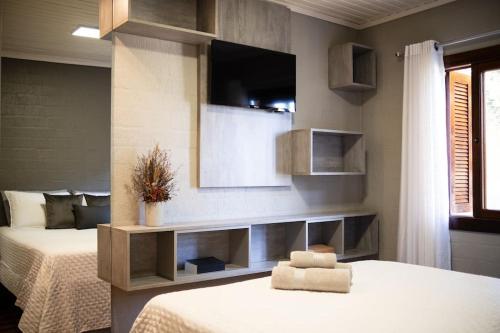 a bedroom with a bed and a tv on the wall at Casa de Campo Warmup in Caxias do Sul