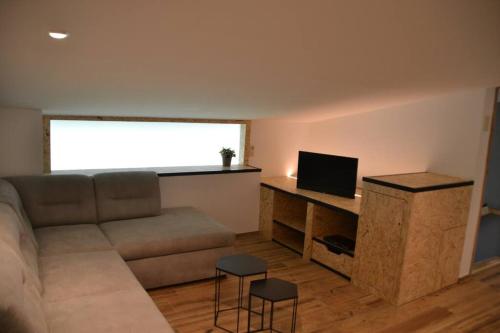 a living room with a couch and a television at Loft spa et wellness Obanoa in Vaux-sur-Sûre