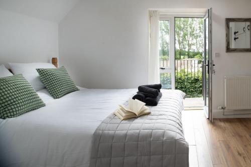 a bedroom with a white bed with a book on it at The Milking Parlour in Malmesbury
